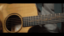 a close up of an acoustic guitar with a floral design on it