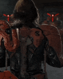 a man in a red suit is standing in front of robots