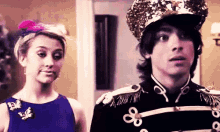 a woman in a blue dress is standing next to a man in a military uniform with 88 on his sleeves