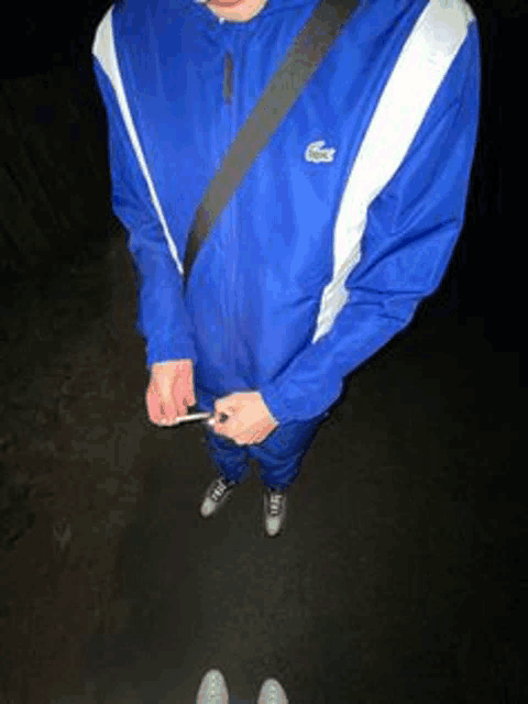 a person wearing a blue jacket with a lacoste logo on the front