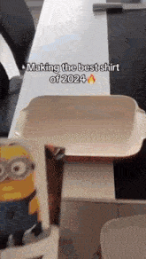 a person is making the best shirt of 2024 with a minion in the background