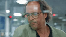 a close up of a man wearing glasses with the hashtag #kalpazan