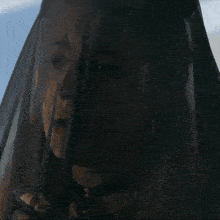 a woman is wearing a black veil over her head