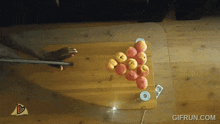 a bunch of apples are on a table with a gifrun.com logo in the corner
