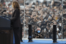 a man wearing mittens is sitting in front of a crowd of people