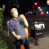 a man is standing in front of a trash can that says los angeles