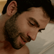 a close up of a man 's face with a beard smiling