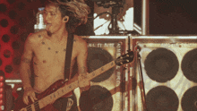 a man without a shirt is playing a guitar in front of a speaker that says " nsl arg "