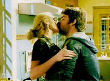 a man and woman kissing in a kitchen