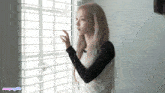 a girl looking out a window with a watermark that says ncsmgirls