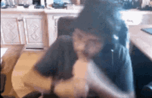 a blurry picture of a man sitting in a chair eating a piece of food .