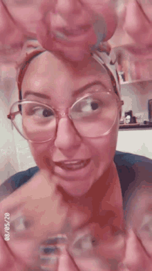 a woman wearing glasses and a headband looks at the camera