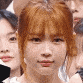 a close up of a woman 's face with red hair in a crowd .