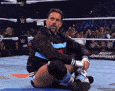 a wrestler is kneeling down in front of a night champions sign