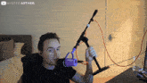 a man is holding a shure microphone in front of a youtube logo