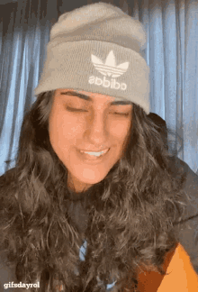 a woman wearing a beanie with the word abbibb on it