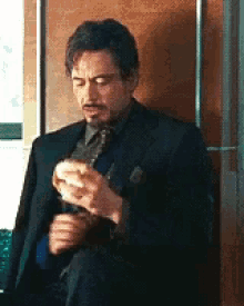 a man in a suit and tie is eating a sandwich .