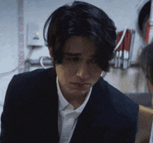a man in a suit and white shirt looks down