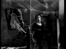 a woman in a black and white photo is holding a spider web .