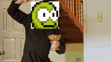 a priest is holding a chalice in front of a door with a green pixelated face on his face