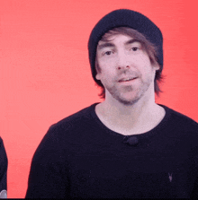 a man wearing a beanie and a black shirt with a rabbit on it