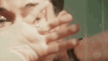 a close up of a person 's face with their hand covering it .