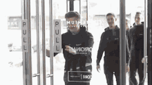 a group of men are walking through a doorway with a sign that says pull