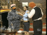 a man in a suit is standing next to a clown and a duck costume .