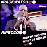 a man in a suit is smoking a cigarette and says rip bozo rest in piss you won t be missed