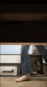 a person 's feet are visible under a table