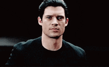 a blurry picture of a man 's face in a dark room with his hands on his head .