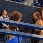 a group of people sitting in a stadium talking to each other .