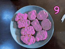 a blue plate with pink nuggets and the number 9