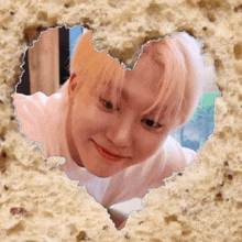 a heart shaped hole in a piece of paper with a picture of a boy in it