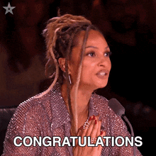 a woman sitting in front of a microphone with the word congratulations written on her face