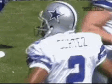 a football player wearing a white jersey with the number 2 on it