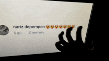 a person 's hand is visible in front of a screen that says " nariz.depompon "