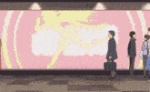 a group of people are standing in front of a large billboard with a picture of a woman on it .