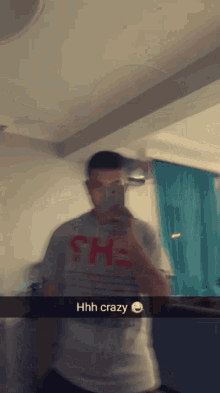 a blurry picture of a man taking a selfie with the words hhh crazy