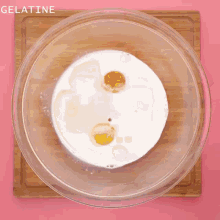 powdered sugar is being poured into a glass bowl with eggs