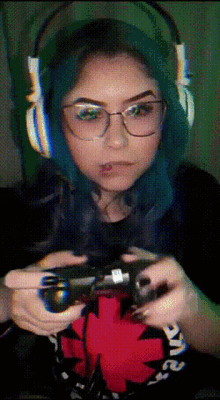 a woman wearing headphones and glasses is holding a controller