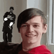 a young man in a red hoodie is smiling in front of a statue of a man .