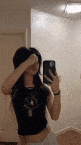 a woman taking a picture of herself in the mirror
