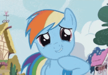 a cartoon pony with a rainbow mane and tail is smiling and looking at the camera .