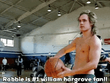 a shirtless man is holding a basketball in a gym and says robbie is # 1 william hargrove fan