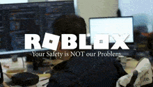 a man sitting in front of a computer with the roblox logo on the top