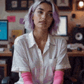 a woman with purple hair is sitting in front of a computer