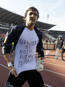 a man wearing a white shirt that says oprosti mi moju ruznyk proslost