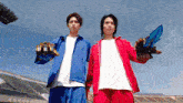 two men in blue and red jackets are holding their weapons