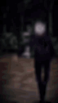 a blurry picture of a person 's face with a gray haircut and a black background .